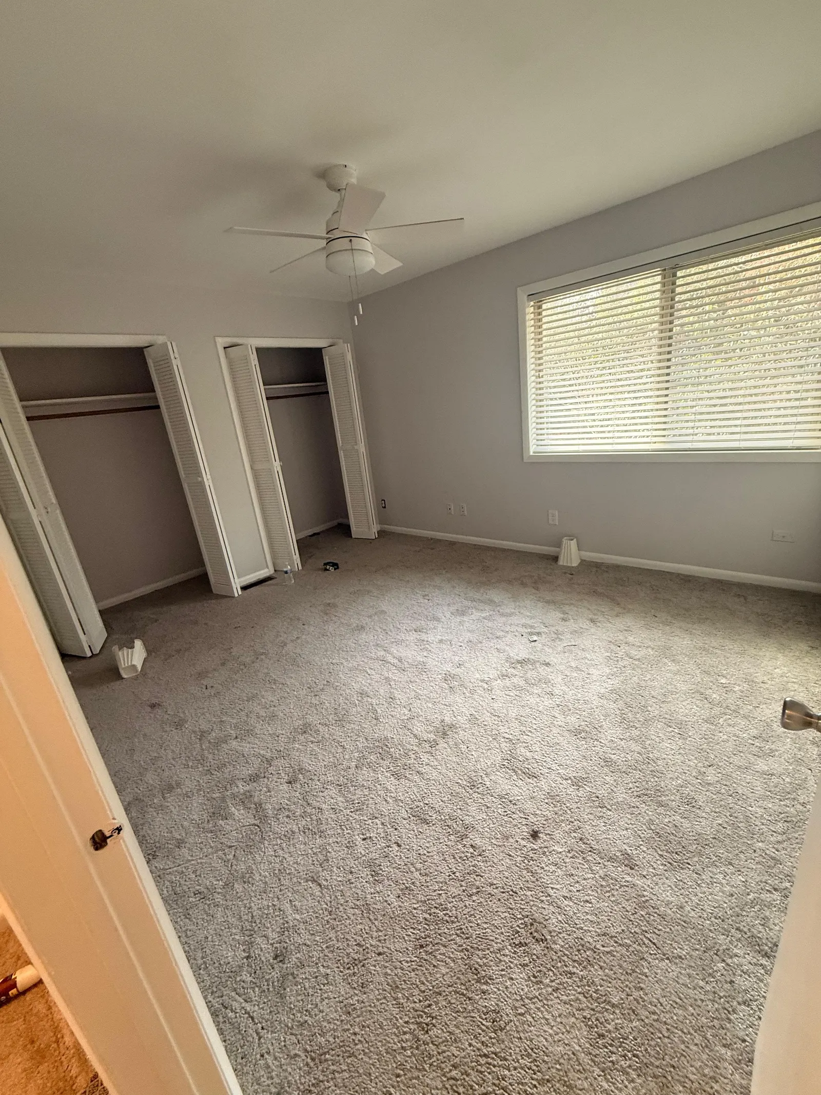 Empty bedroom with dirty carpet before move-out cleaning in a Willow Spring, NC home